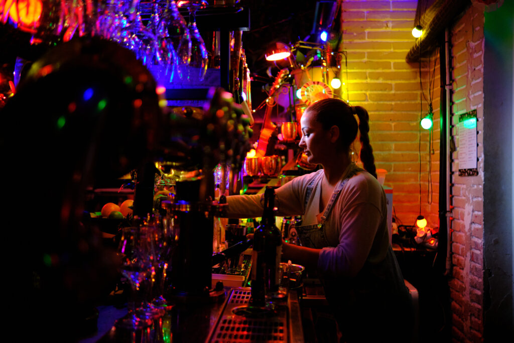 Female bartender working behind the counter of a bar.
